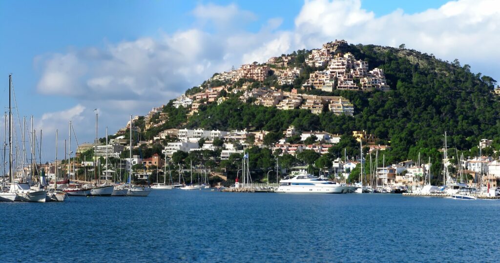 Beliebte Wohngegend in Andratx. Ausläufer des Tramuntana Gebirges in Andratx. Gesäumt mit Häusern. Meer im Vordergrund mit Booten.